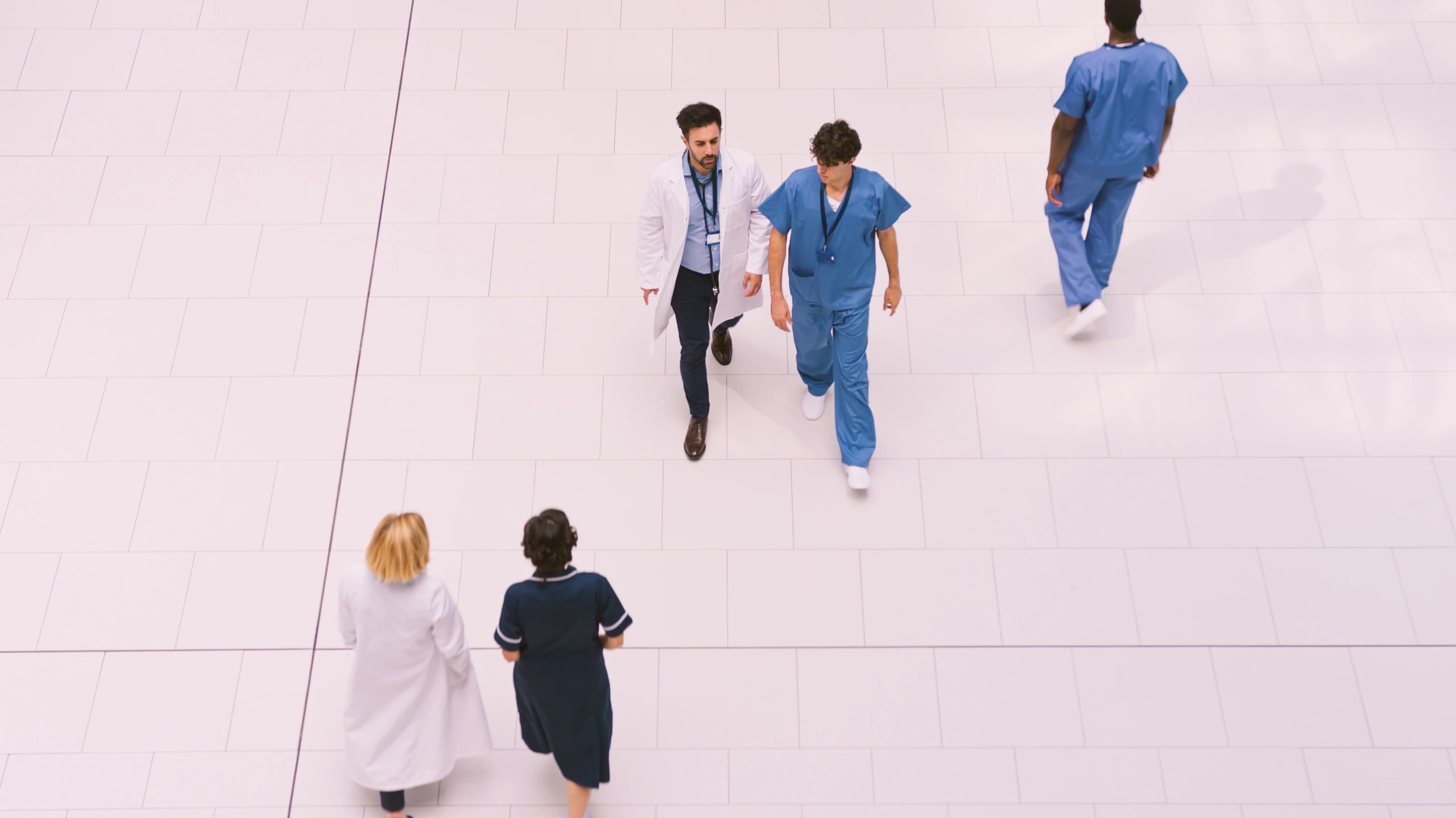 Medical staff crossing lobby of modern hospital building