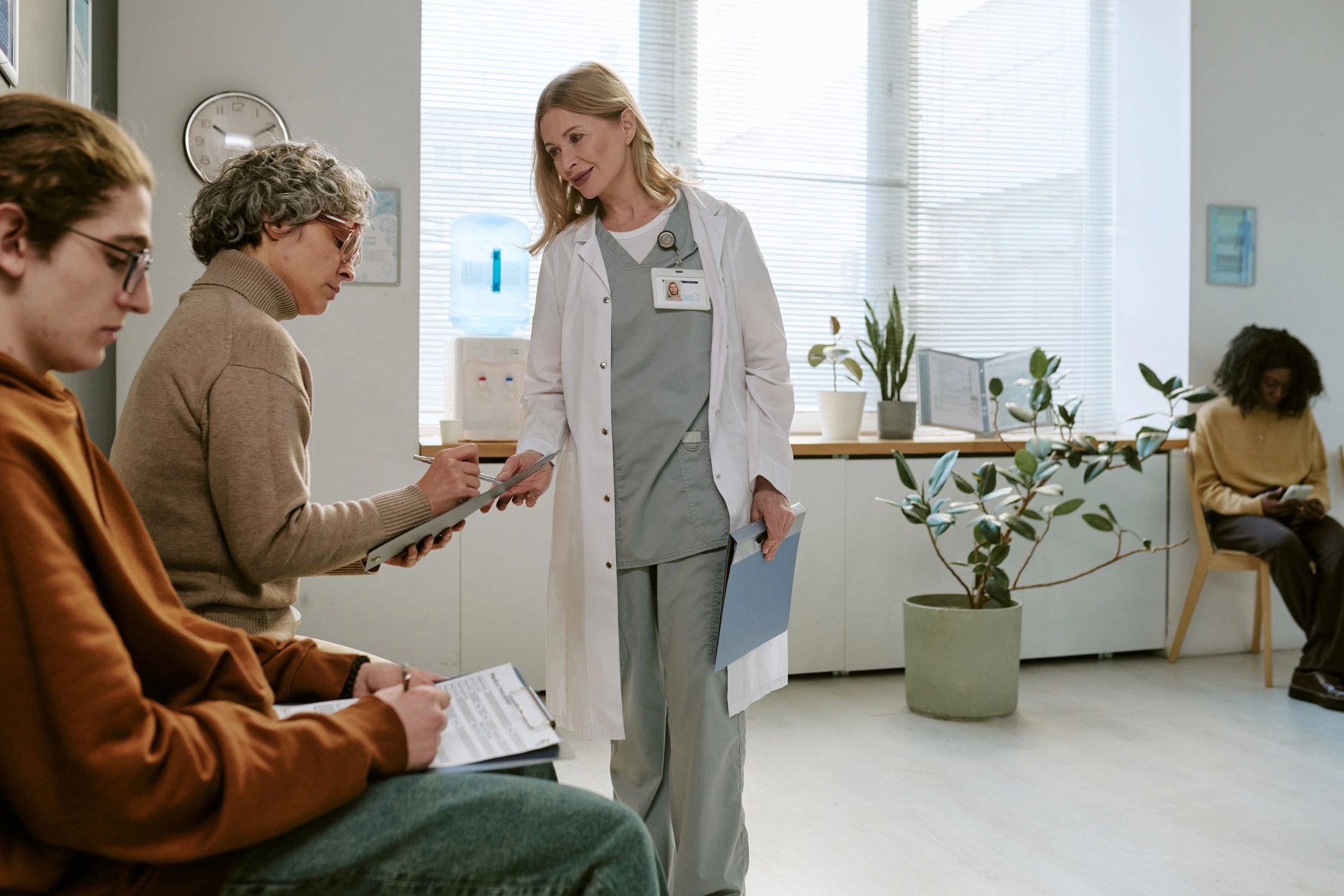 Female doctor assisting senior woman with clinic intake forms